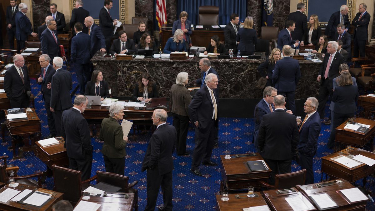 A quiet congressional hallway with closed doors and staffers carrying folders.
