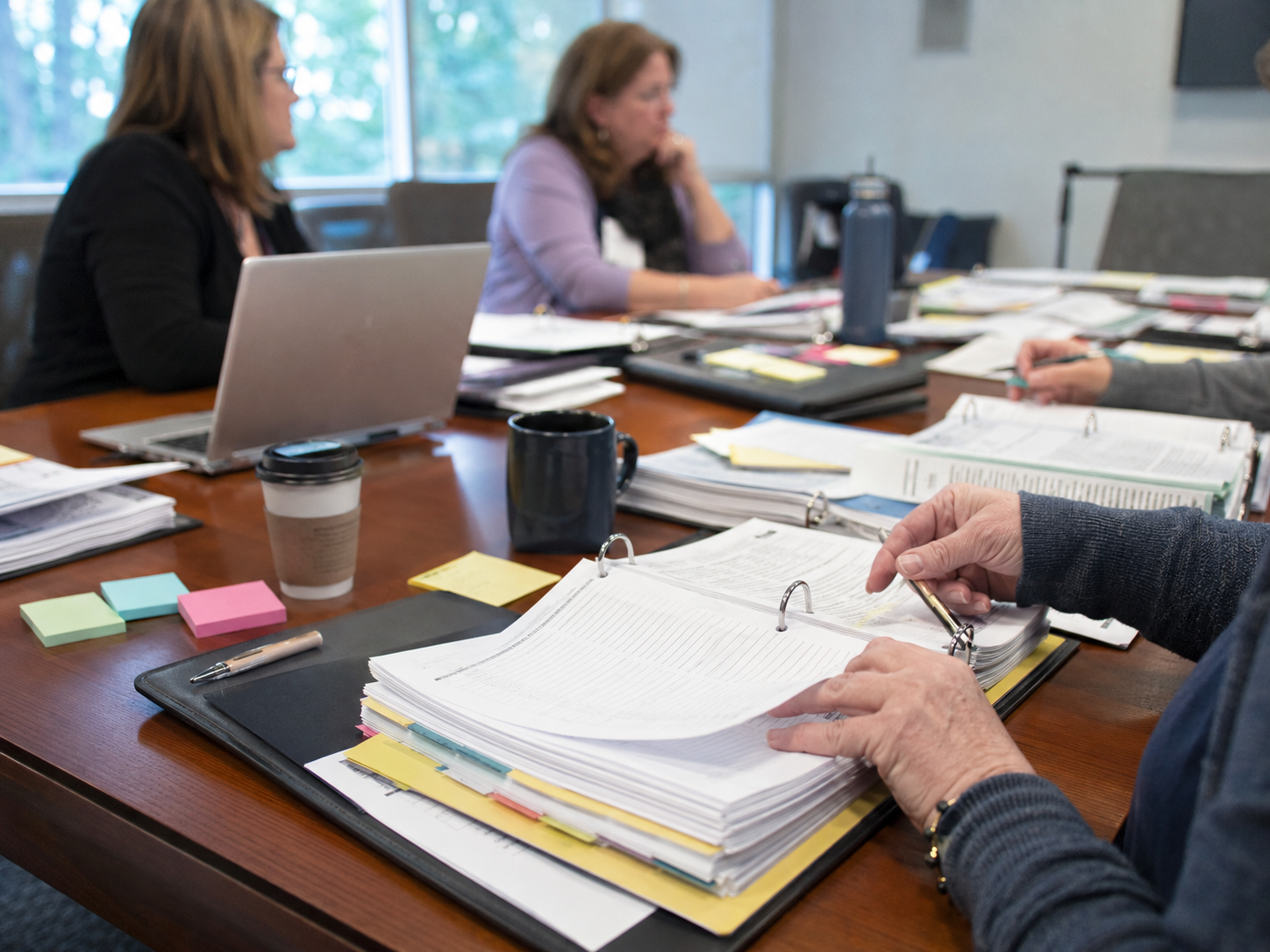 College accreditation and student aid documents sit on a conference table.