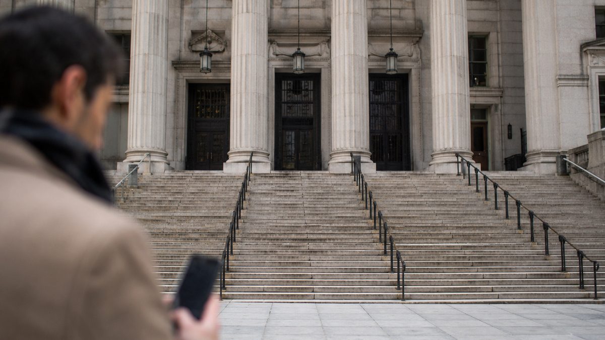 A smartphone held near the exterior of a courthouse.