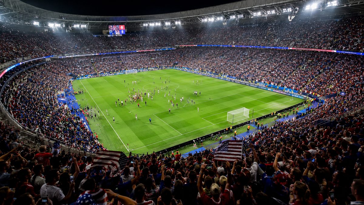 Empty soccer stadium under bright lights after a major tournament match.