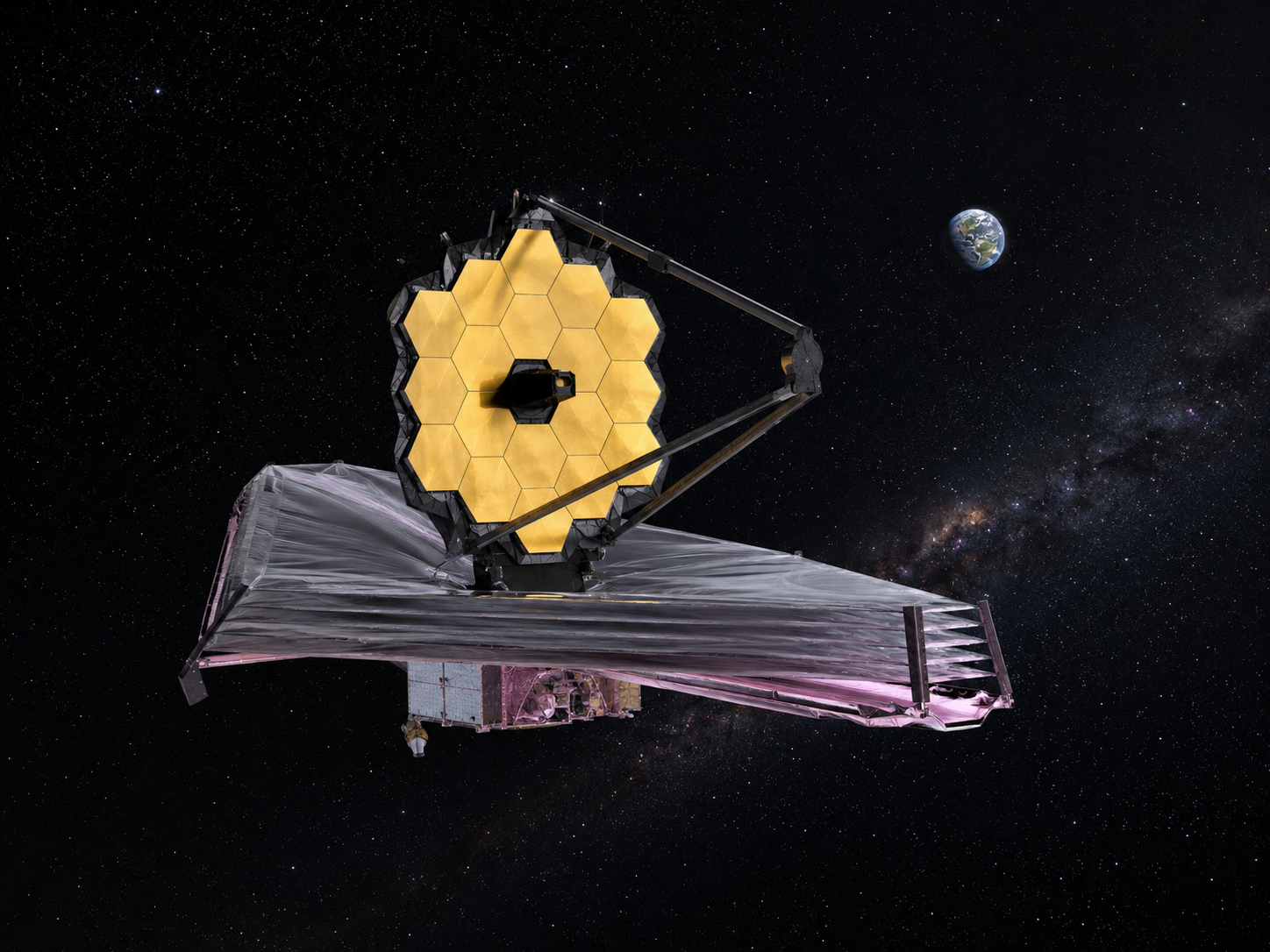 An astronomy workstation with a blurred deep-field galaxy image on a monitor.