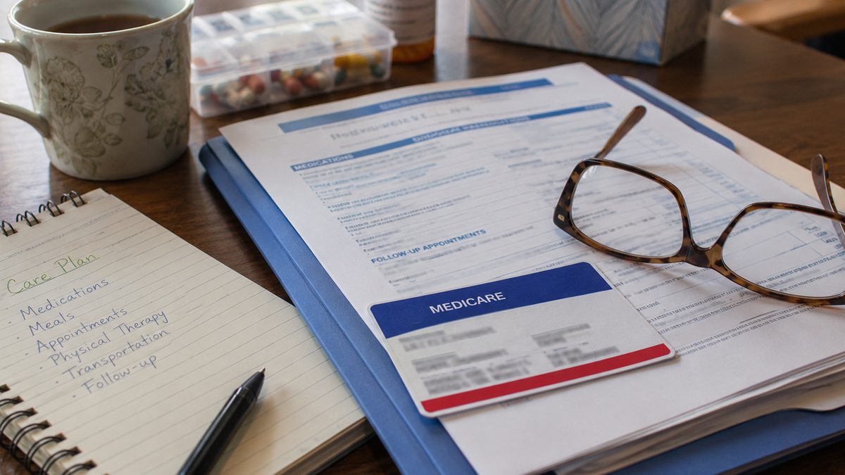 Hospital paperwork and a caregiver notebook on a table.