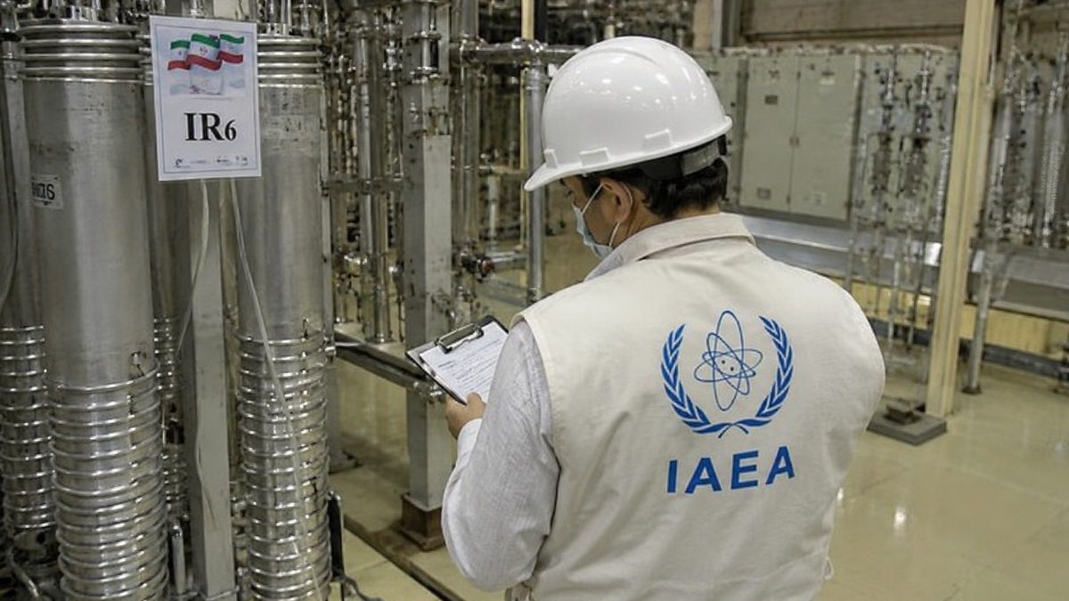 Diplomats meeting at an international conference table during negotiations involving Iran and international officials.