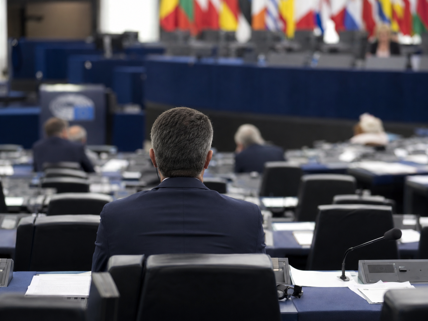 European parliament chamber with empty desks after a government vote.