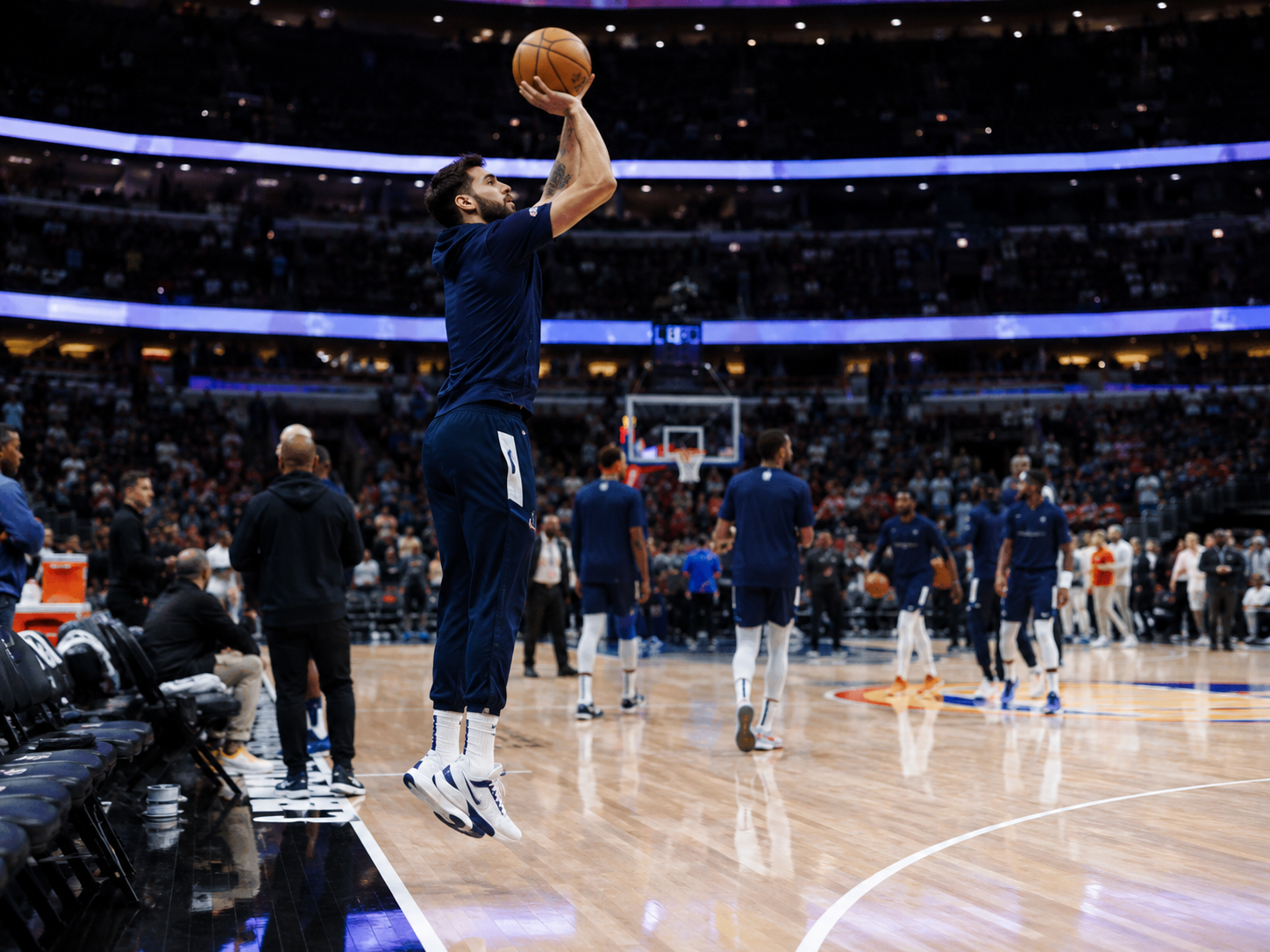 A professional basketball arena during playoff warmups before a high-stakes game.