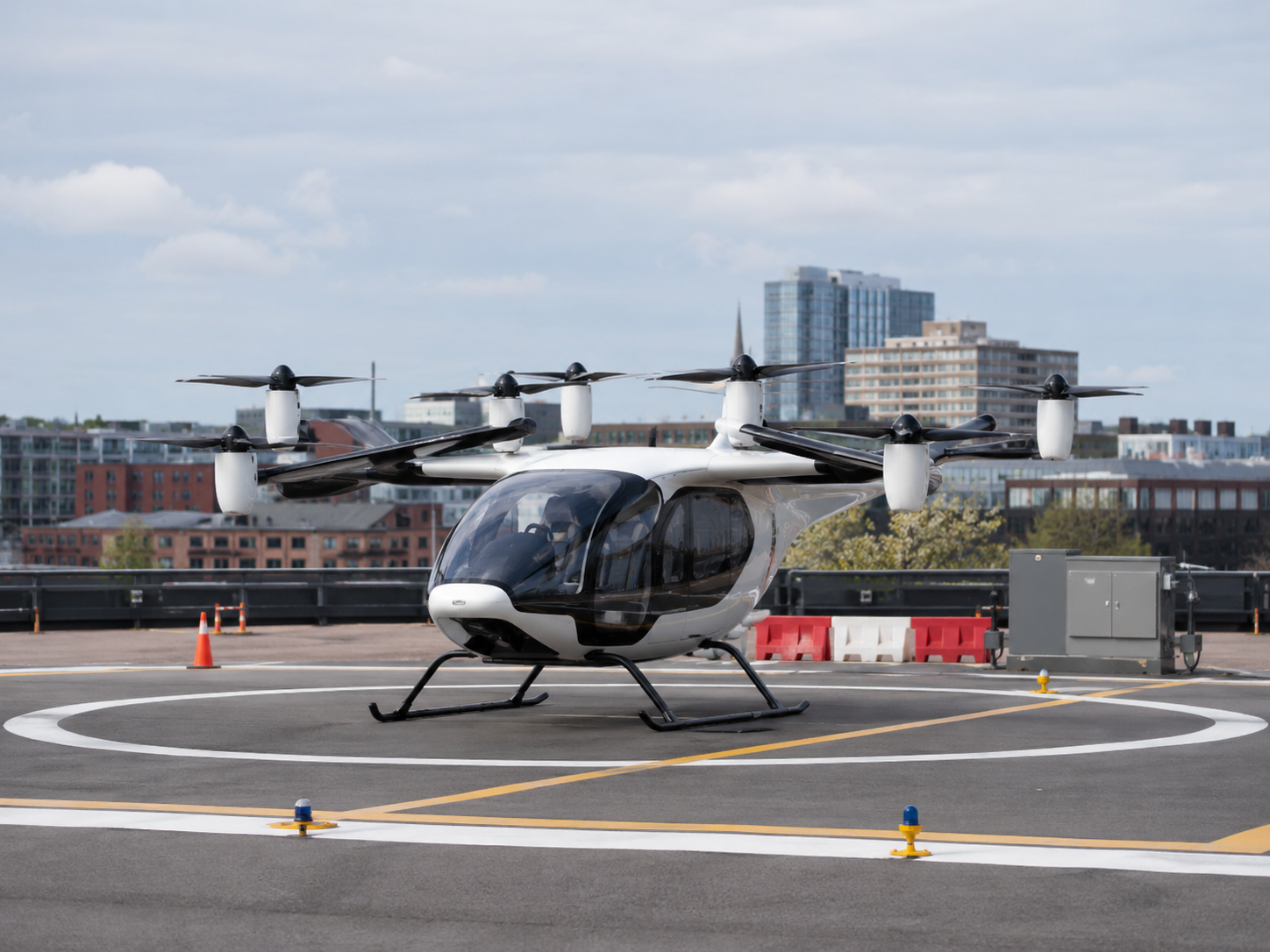 An electric air taxi prototype sits at a test landing area.