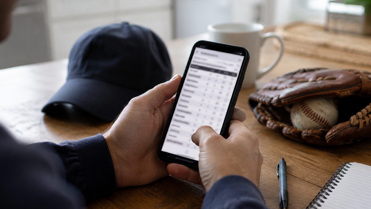 Fan looking at a baseball voting screen on a phone beside a glove.