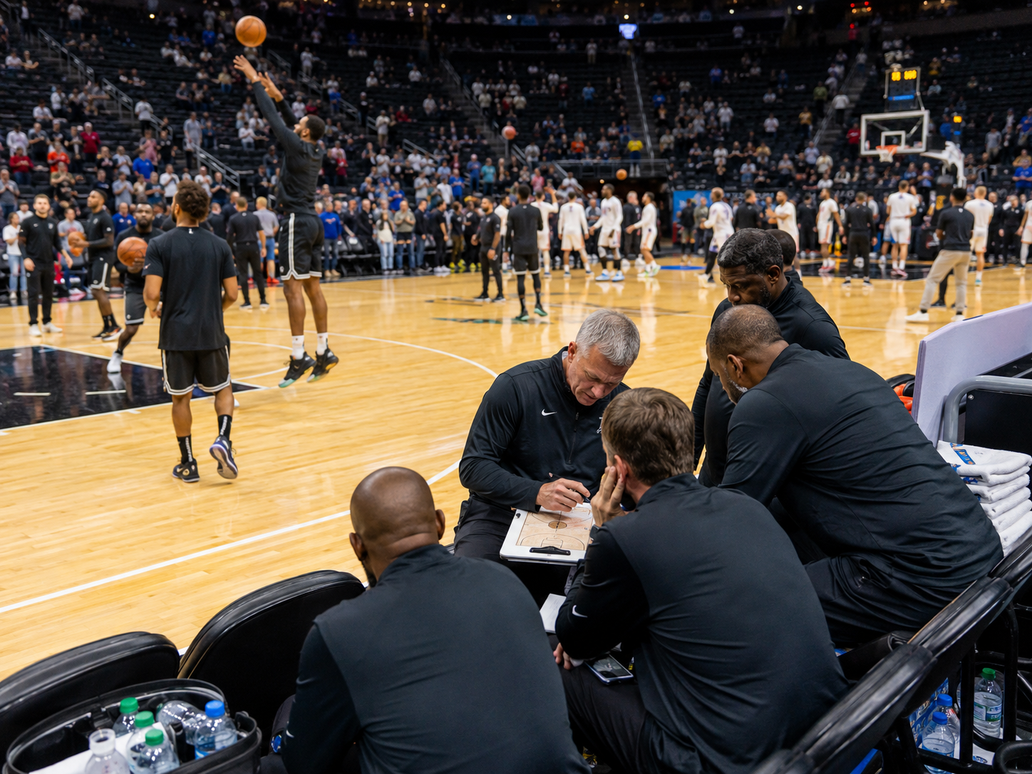 A basketball arena before a playoff game with players warming up and fans entering the stands.
