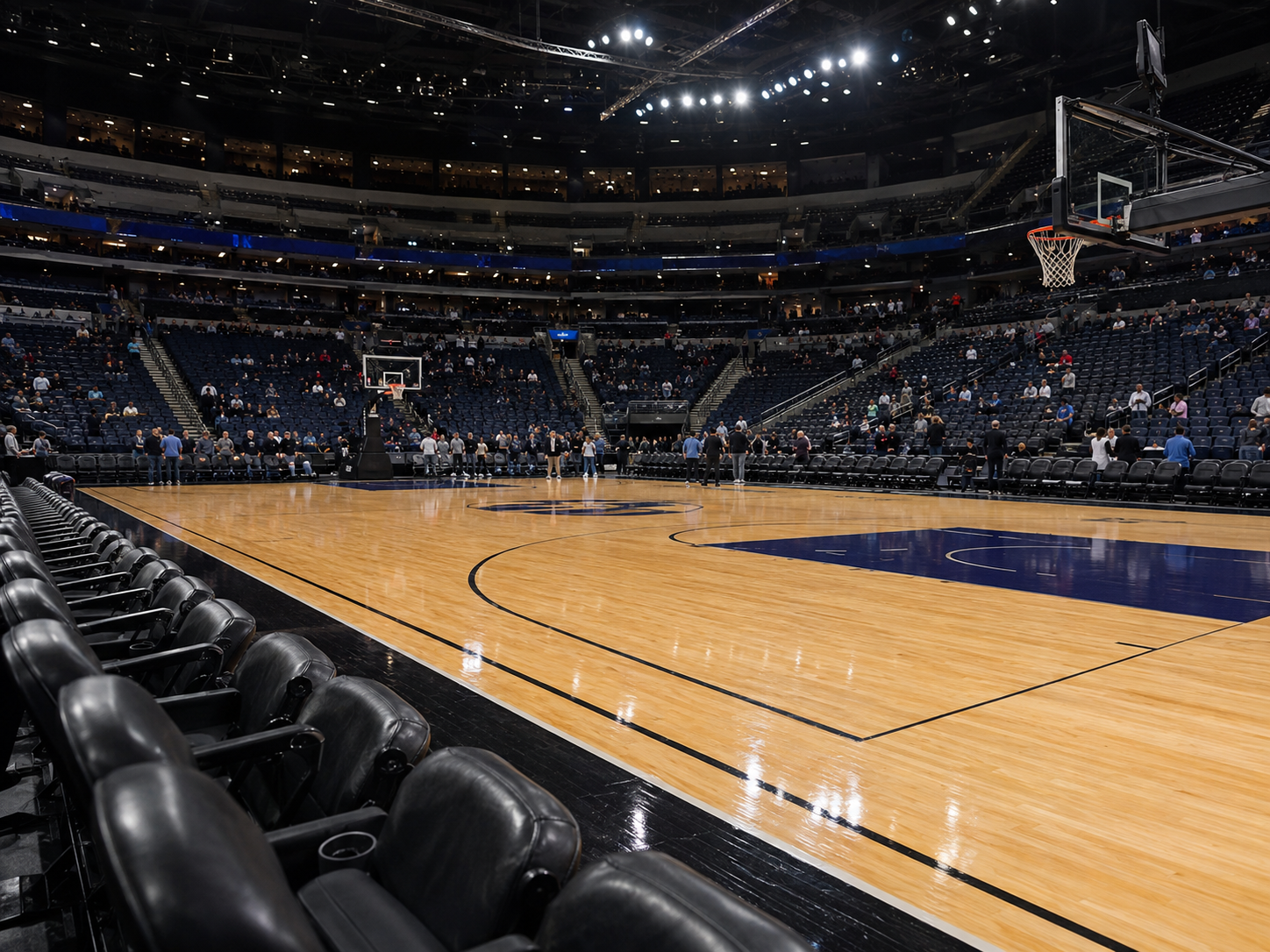 An empty basketball arena under bright lights before a championship game.