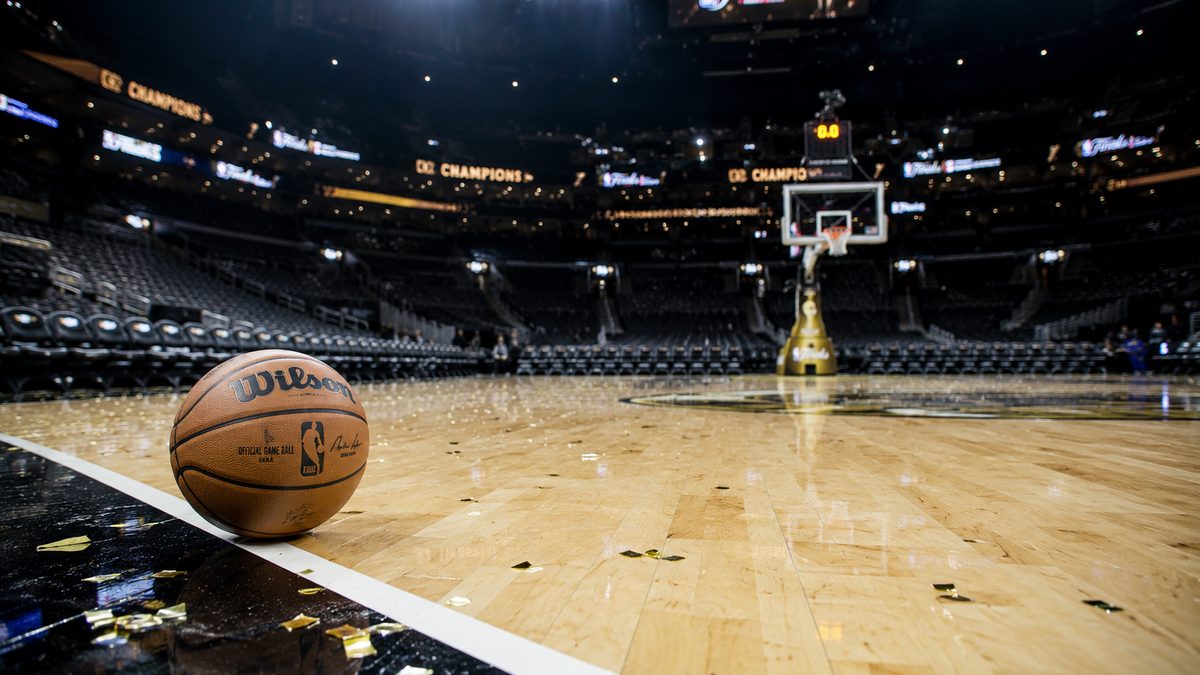 Basketball resting near the sideline of an empty arena after a major game.
